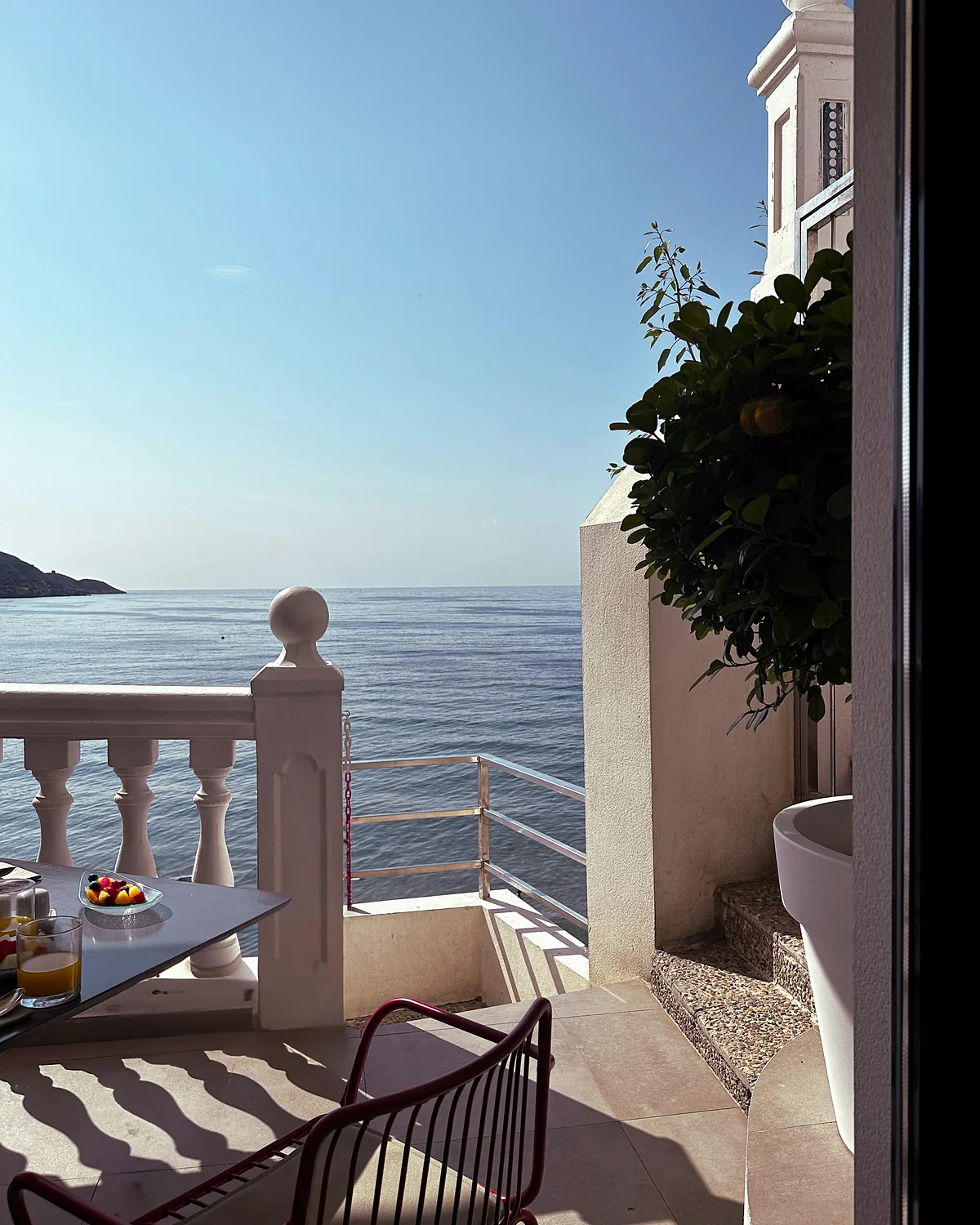 Balcony table and chairs above the sea at a Mediterranean hotel