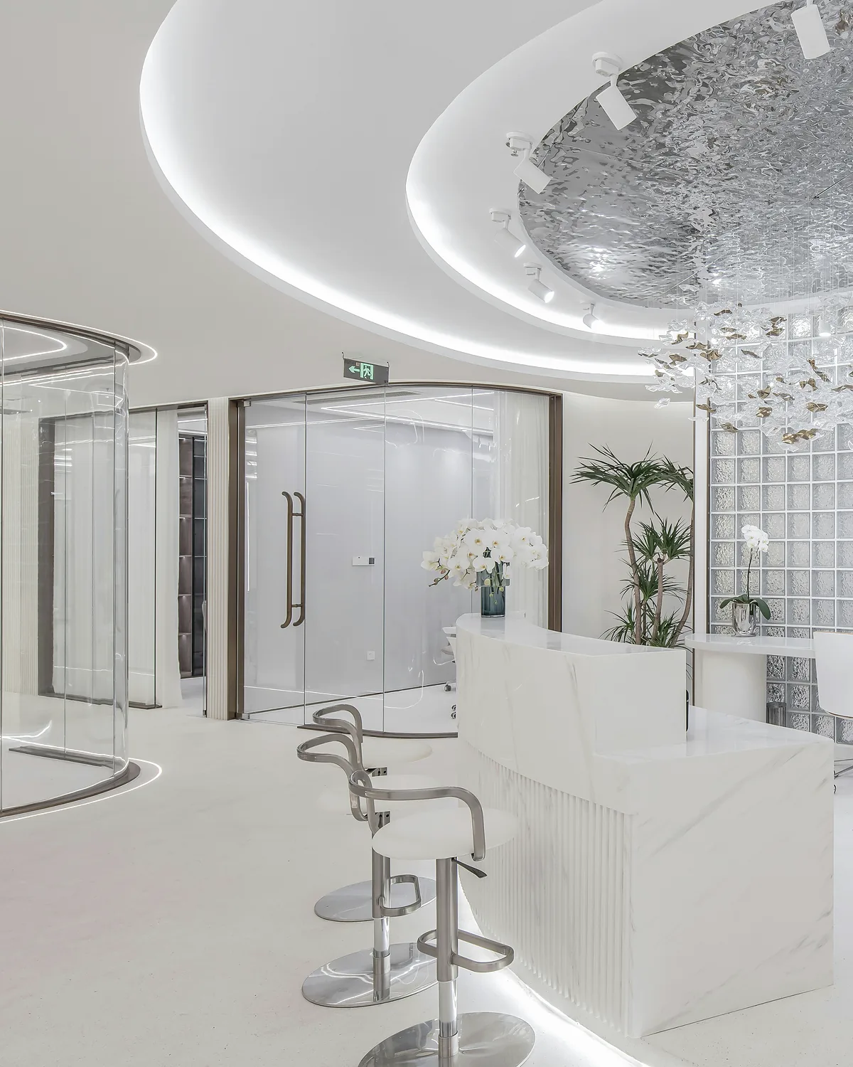 Bright white reception area with curved ceiling detail and orchids